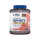 A 20kg tub of Applied Nutrition Critical Whey Advanced Protein in Strawberry Milkshake flavor, featuring a dark translucent container, blue cap, and a white label with pink and blue graphics.